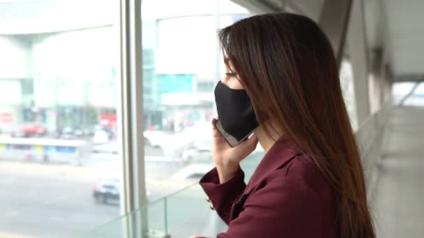 亚洲女商人戴着保护面具 一边用智能手机交谈 验尸官 的概念 — 图库视频影像