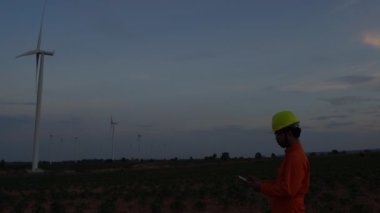 Rüzgar türbini çiftliği Güç Üreteç İstasyonunda çalışan ve raporu tutan mühendis.