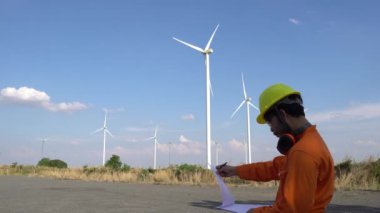 Rüzgar türbini çiftliği Güç Üreteç İstasyonunda çalışan ve raporu tutan mühendis.