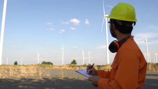 Inżynier Pracujący Trzymający Raport Elektrowni Wiatrowej Górach — Wideo stockowe