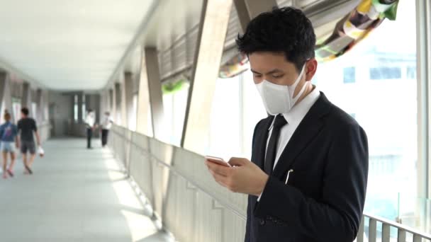 在商务中心使用智能手机时戴面具的亚洲男人 验尸病毒的概念 — 图库视频影像