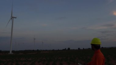 Rüzgar türbini çiftliği Güç Üreteç İstasyonunda çalışan ve raporu tutan mühendis.