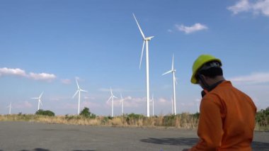 Rüzgar türbini çiftliği Güç Üreteç İstasyonunda çalışan ve raporu tutan mühendis.