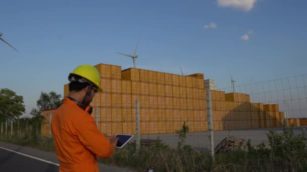山の風力発電所発電所で働いて報告書を保持する技術者 — ストック動画