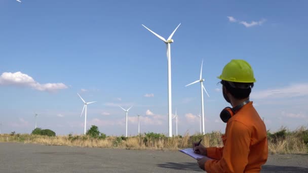 山の風力発電所発電所で働いて報告書を保持する技術者 — ストック動画