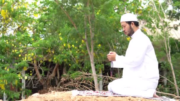 年轻的亚洲穆斯林男子在斋月节日期间在户外祈祷 — 图库视频影像