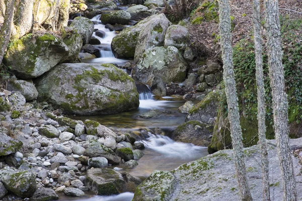 Background of crystal clear water running between the stones — Stockfoto