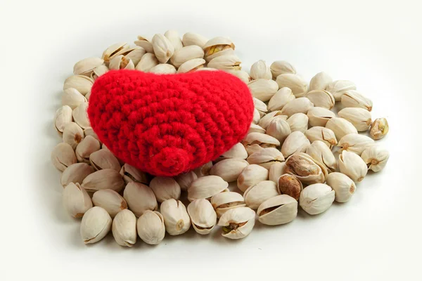 Pimpernoten (pistaches) en brei garen vormen een rode horen — Stockfoto