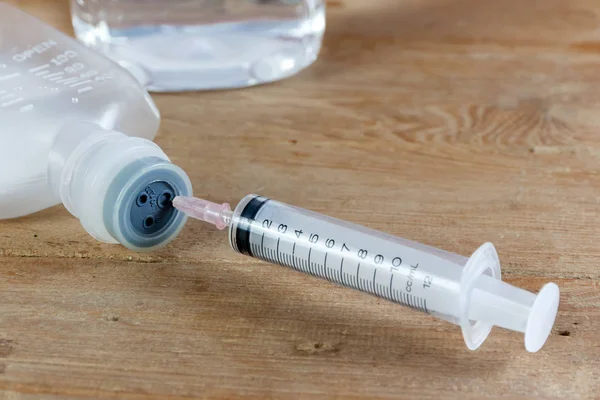 Saline solution and injection needle — Stock Photo, Image