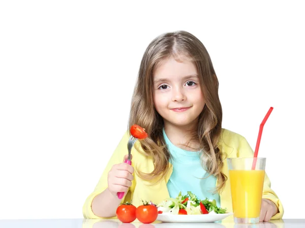 Child eats vegetables drinks juice isolated on white. — Stockfoto