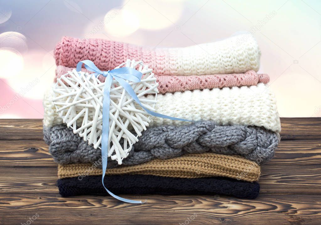 Stack of knits on wooden background.