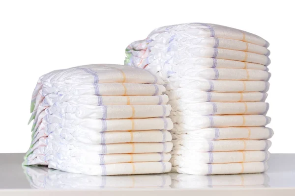 Stack of diapers on table isolated on white. — Stock Photo, Image