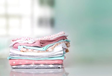 Pastel bebek giysileri yığın yığın boş alan arka plan.