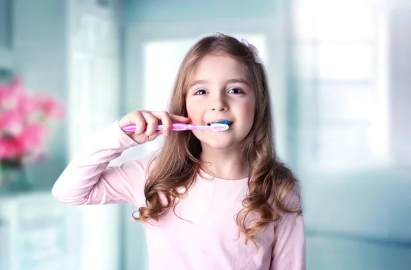 Menina branca limpando os dentes no banheiro . — Fotografia de Stock