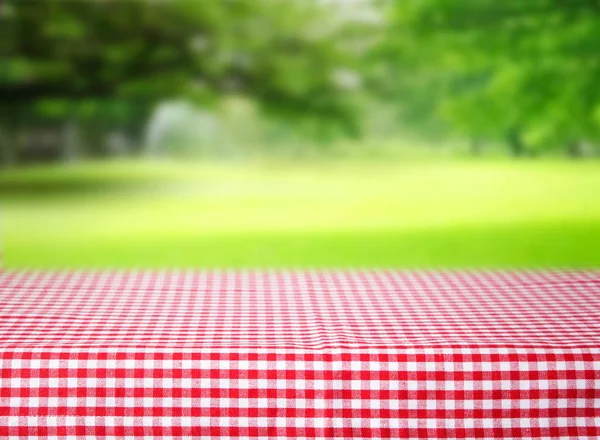 Checkered tovaglia rossa emty spazio tavolo sfondo verde . — Foto Stock