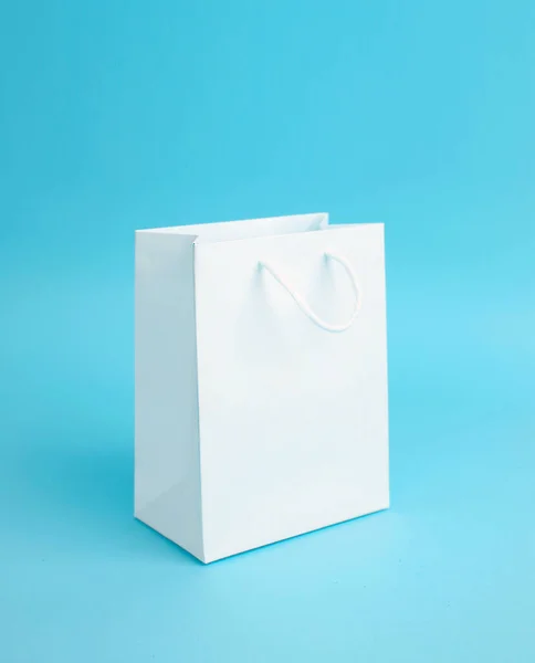Witte lege papieren zak op blauwe achtergrond. — Stockfoto