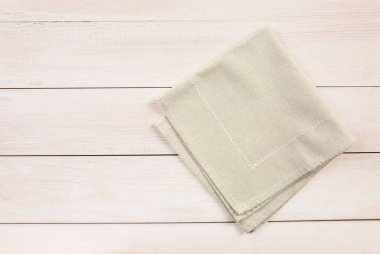 Bej katlanmış mutfak bezi ahşap arka planda üst görünümde. Çuval bezi besin dekorasyonu, arka plan..