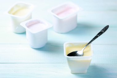 Masanın üzerinde plastik pakette taze yoğurt. Renkli yoğurtlar. Hafif atıştırmalıklar..