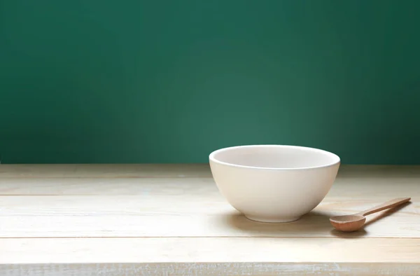Bowl on wooden empty space table and green background.Food backdrop.Empty plate.