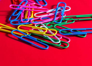 Farklı arkaplanda çok renkli ataçlar