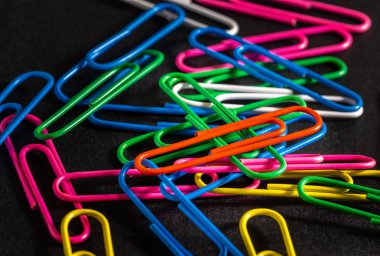 Farklı arkaplanda çok renkli ataçlar