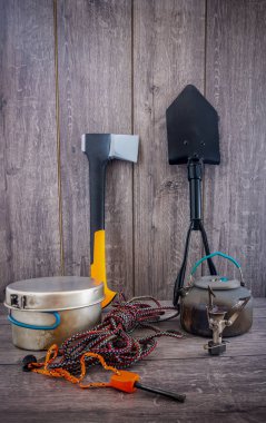 Ahşap masada kamp malzemeleri kullanılmış.