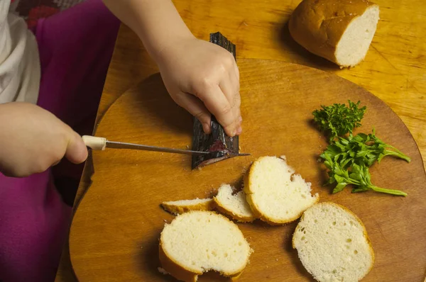 Küçük kız sandviç yapmak için malzemeleri hazırlıyor.