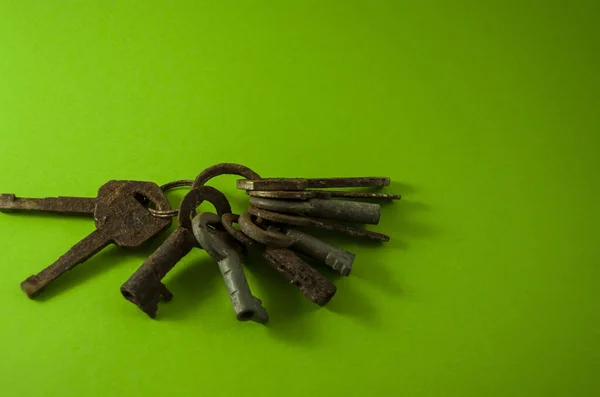 Alte rostige Schlüssel auf grünem Hintergrund — Stockfoto