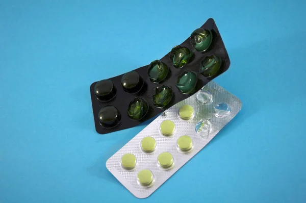 Yeşil haplar, vitaminler, tablet, mavi arka planda ilaç.