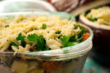 Patatesleri tencerede pişirmek için hazırlıyorum. Çiğ patates, et, soğan, havuç, maydanoz, cam ve seramik kaplarda peynir. Pişirmeye hazır. Kırsal mutfak