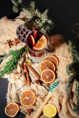 Karanlık bir arka planda sıcak şarap, portakal ve ladin dallarıyla Noel kompozisyonu. Kış içkisi. Sıcak Noel Sıcak Şarap. 