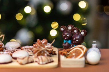Noel kurabiyeleri ve çikolatalı fareler Noel ağacının önünde bokeh ışıklarıyla.