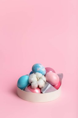 Paskalya süslü yumurtalarla pembe arka planda bir kutuda güzel sakin bir hayat..