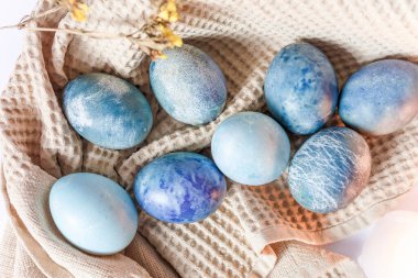 Renkli paskalya yumurtaları ve beyaz arka planda kırsal tarzda bahar çiçekleri olan güzel sakin bir hayat..