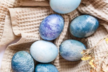 Renkli paskalya yumurtaları ve beyaz arka planda kırsal tarzda bahar çiçekleri olan güzel sakin bir hayat..