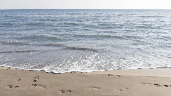 Zee en voetafdrukken in het zand — Stockfoto