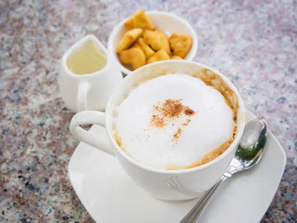 Weiße Tasse Cappuccino steht auf dem Gesteinstisch, selektiver Fokus — Stockfoto
