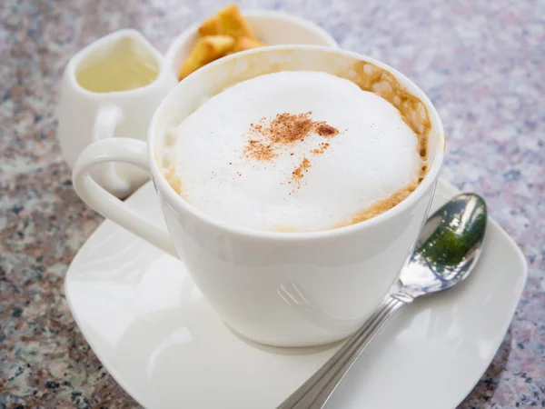 Weiße Tasse Cappuccino steht auf dem Gesteinstisch, selektiver Fokus — Stockfoto