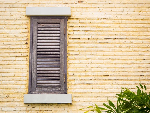 Vintage trä fönster på gula tegelväggen — Stockfoto