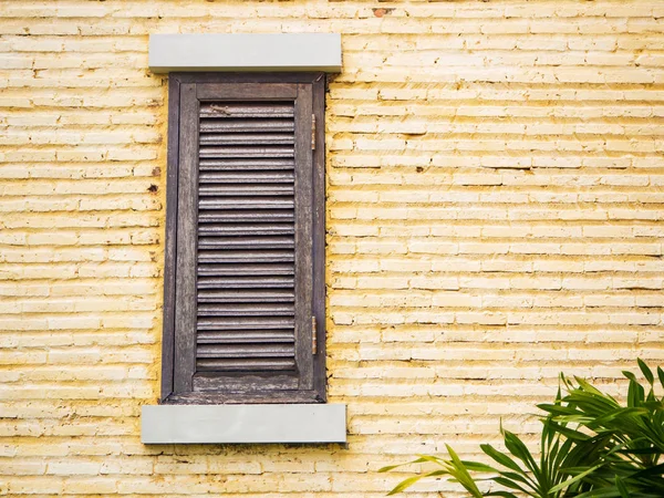Vintage trä fönster på gula tegelväggen — Stockfoto