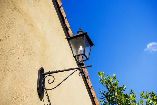 Lampu gantung besi klasik di dinding semen dengan langit biru — Stok Foto