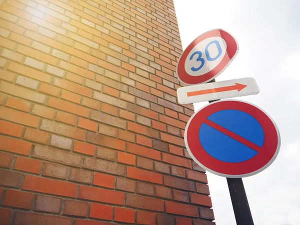 Vintage traffic sign post on the street and brick wall