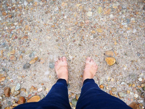 Bare Feet on the beach with sea water and rock — Stock Photo, Image