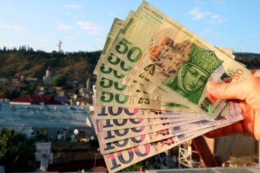 Gürcistan 'ın 50 banknotunun bir kısmı Arka planda Bulanık Tiflis Şehir Görünümü ile Obverse Side' ı gösteriyor