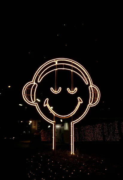 街边挂着幸福的笑脸霓虹灯的垂直图像 — 图库照片
