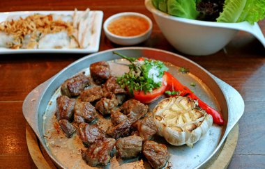 Beef steak with grilled vegetables served on sizzling hot iron plate