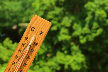 Yaz güneşinde ahşap termometre yüksek sıcaklık gösteriyor.