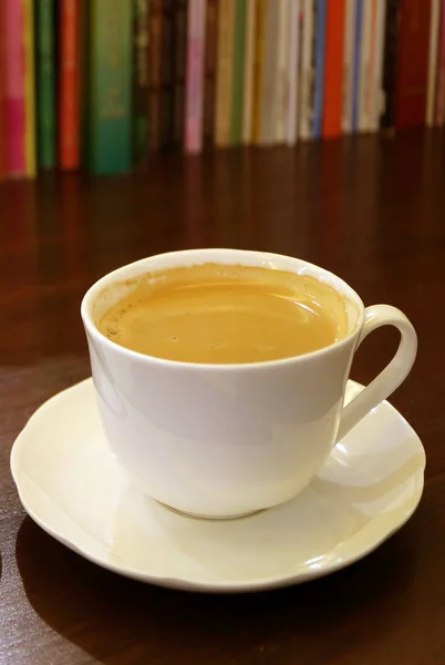 Eine Tasse Heißen Kaffee Auf Dunkelbraunem Holztisch Mit Verschwommener Bücherreihe — Stockfoto