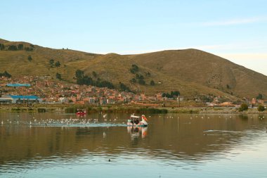 İnsanlar Peru 'nun Puno şehrinde Titicaca Gölü' nde sürat teknesinin keyfini çıkarıyorlar.