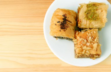 Farklı lezzetlerdeki Baklava Pastalarının Tahta Masa üzerinde fotokopi Alanıyla Üstten Görünümü